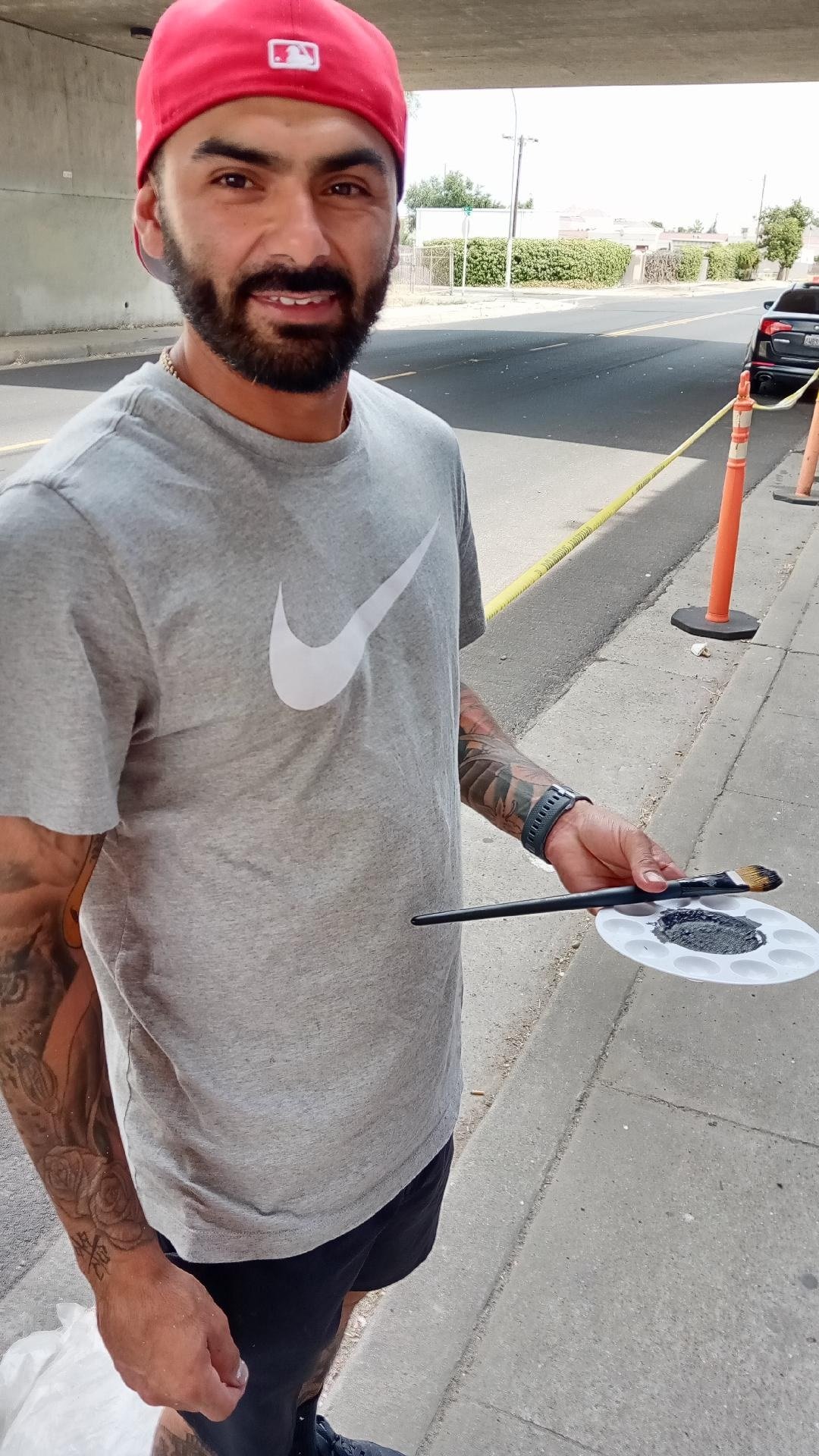 Martin Figueroa with his pallet and brush working on the Canal Street underpass mural in Merced. Photo: Steve Newvine
