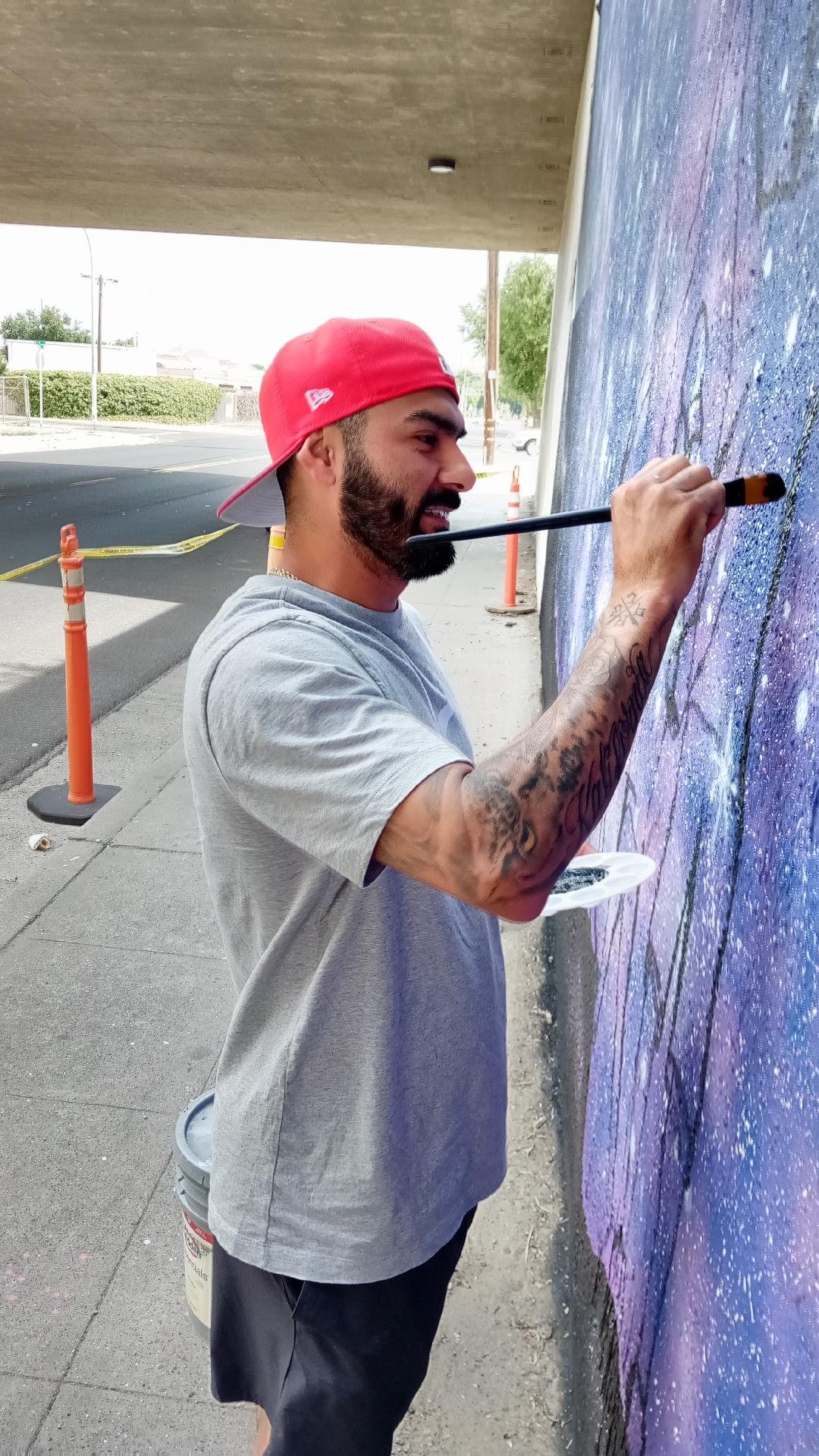 Martin is applying what would be one of the final touches to his mural project; the final strokes in honor of his children. Photo: Steve Newvine